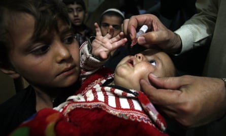 A Pakistani health worker gives a vaccination to a child in Peshawar.