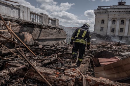 A firefighter walking through the rubble of a destroyed building