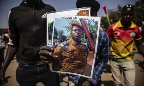 A man holds a portrait of Lt Col Paul-Henri Sandaogo Damiba, who led a coup overthrowing the president  earlier this year.