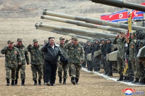 Kim Jong-un (C) salutes personnel during a military training competition at an undisclosed location