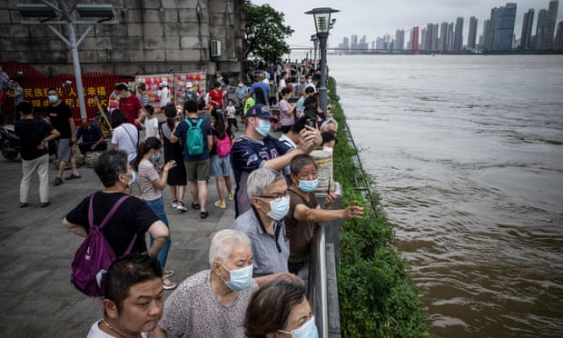 Residents watch the swollen Yangtze River in Wuhan, in China’s central Hubei province, on 12 July.
