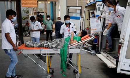 A patient wearing an oxygen mask is wheeled inside a Covid-19 hospital for treatment in Ahmedabad.