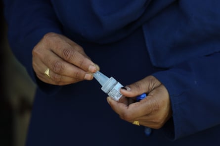 A woman’s hands hold a vial of polio vaccine
