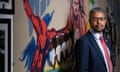 Vaughan Gething at a community centre in Cardiff: he is standing in front of a bright mural celebrating Windrush-era immigration