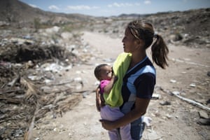 Marbelis Brito holds her seven-month daughter Antonela at the Pavia rubbish dump