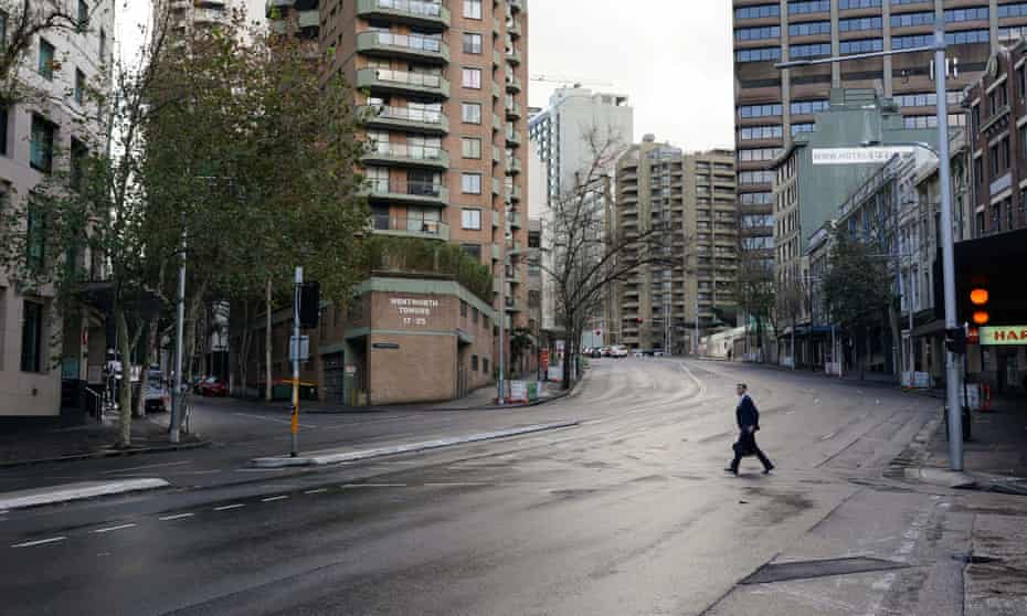 A pedestrian crosses an empty intersection at morning commute hour in Sydney’s city centre on Monday during a lockdown to curb the spread of the Delta variant of coronavirus.