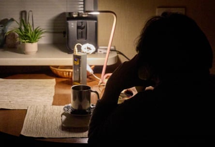 A woman powers a small reading lamp with a power bank