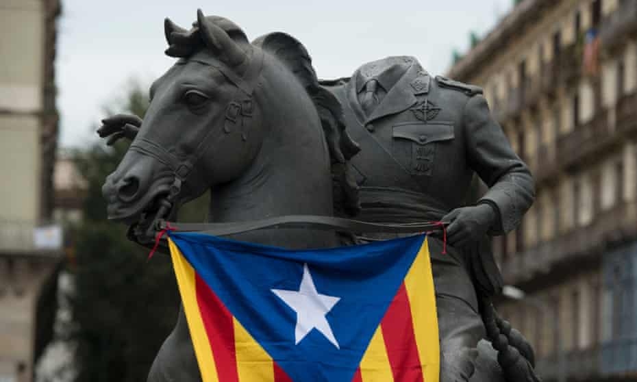 A beheaded sculpture of Francisco Franco riding a horse is draped with a Catalan independence flag in Barcelona.