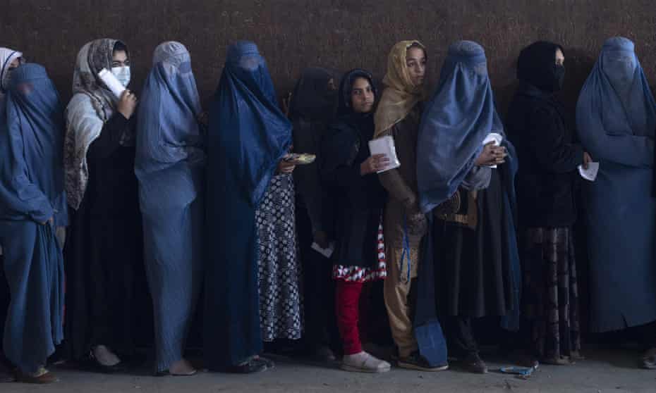 Women queue to receive cash at a distribution point organised by the World Food Programme in Kabul on 20 November.