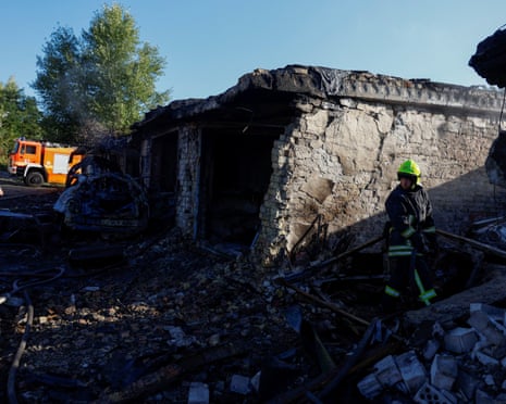 A firefighter works at the site of private car garages hit by a Russian missile strike in the town of Vyshhorod.