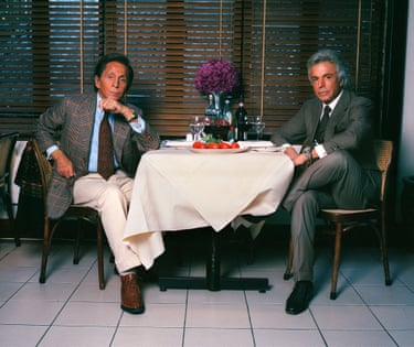 Valentino sits at a table in a restaurant with his business partner Giancarlo Giammetti