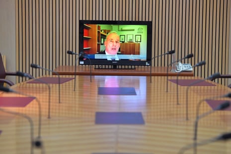 It’s a lonely position for the aged care minister Richard Colbeck, who is videoing in to the senate committee room in Canberra.