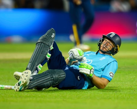 Jos Buttler lies on the ground grimacing in pain during a cricket match