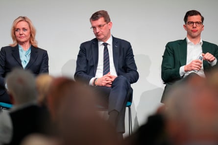 Three politicians siting in a row, looking tired