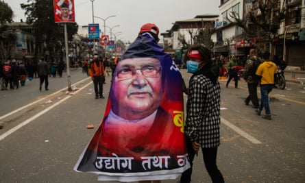 A pro-government activist wrapped in a banner with a portrait of Khadga Prasad Oli.