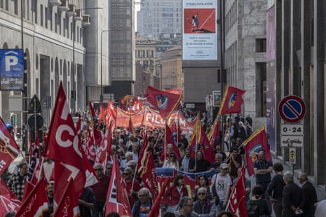 People march during a rally organised for International Labour Day in Milan, Italy.