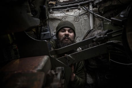 A Ukrainian soldier sits in a tank.