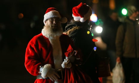 People, dressed in Santa Claus costumes, walk around during power outage in Kyiv