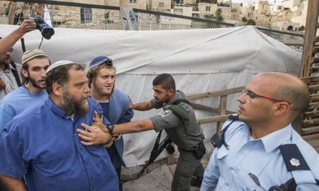An Israeli border guard pushes back Bentzi Gopstein (front left) as he and other members try to cross into the al-Aqsa mosque compound. 