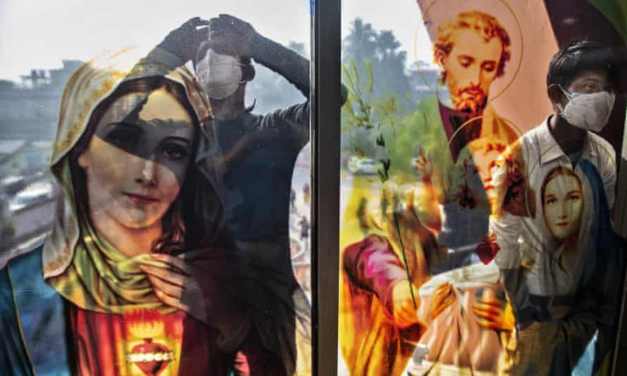 Boys peep through the glass of a church in Gauhati, India, at Christmas. Harassment of Christians has increased in the country.