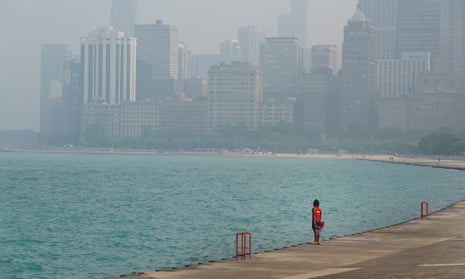 A lifeguard stands watch along the lakefront as wildfire smoke clouds the skyline in Chicago, Illinois. 