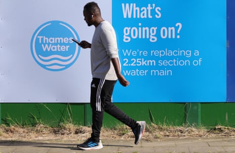 A man passes a Thames Water construction site in London, Britain, 10 July 2024.