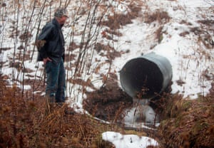David Huff, chairperson of the zoning and planning commission for Osceola Township, stands before Chippewa Creek, shown flowing through a culvert. Residents in the tiny Osceola Township, Michigan complained the Swiss company’s water extraction techniques awere ruining the environment.