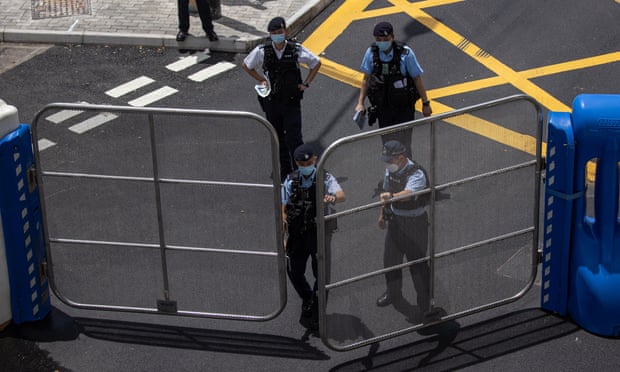 Policemen close an access barrier to Bauhinia Square and hotels used by handover anniversary guests in Wanchai district, Hong Kong