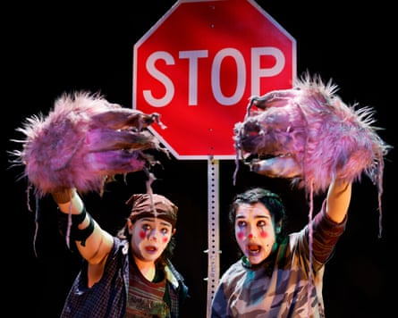 two clowns, Xhloe and Natasha, hold up Bigfoot claws in front of a 'stop' sign