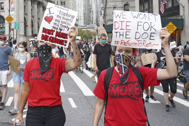 Protesters hold signs during a demonstration against the reopening of schools in New York, New York, on 3 August.