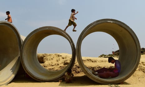 a rohingya child plays on top of concrete pipes in Bangladesh
