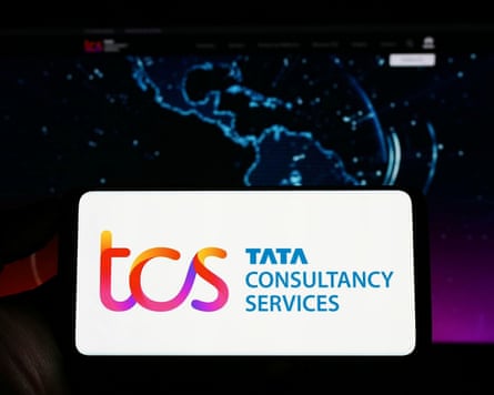 Person holding smartphone with the TCS logo