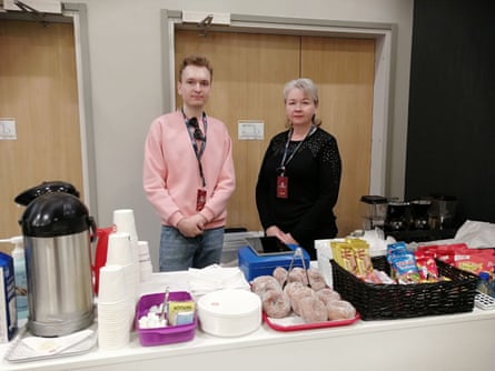 Nikita and Olga Belov stood behind a catering table covered in snacks and hot drinks