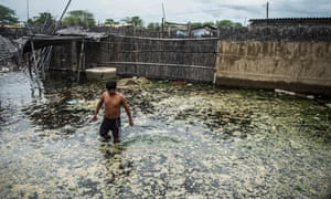 A local wades through muddy waters that have flooded the streets in La Union, northern Peru.