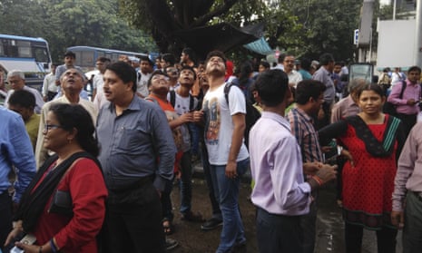 People stand outside their offices after rushing outdoors following tremors in Kolkata, India