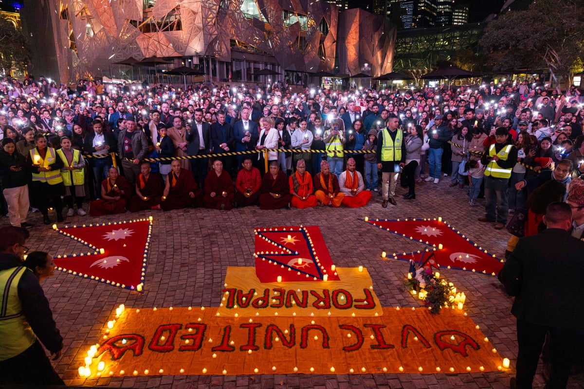 The crowd raises their phone lights and candles at a candlelight vigil in Melbourne for victims of the Nepal floods on Monday night.