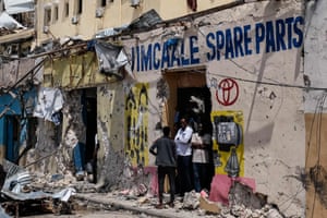 Mogadishu, SomaliaPeople stand at the entrance of a badly damaged building after a deadly 30-hour siege by al-Shabaab jihadists at the Hayat Hotel. At least 13 civilians lost their lives and dozens were wounded in the gun and bomb attack by the al-Qaida-linked group that began on Friday evening and lasted over a day