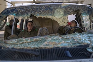 Soldiers rest in a damaged car