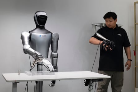 A technician demonstrates teleoperation controls on a humanoid robot