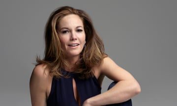 Diane Lane sits on the floor wearing a jumpsuit.