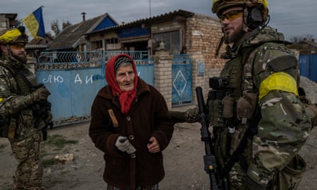 A woman greeting a Ukrainian soldier in the village of Mylove. The writing on the gate reads “People – Children”.