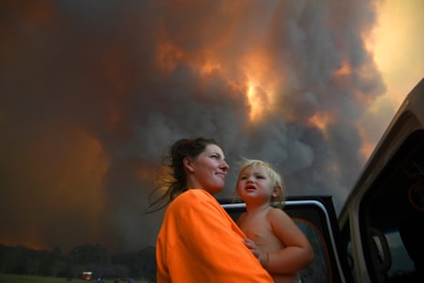 Sharnie Moran and her 18-month-old daughter, Charlotte, as thick smoke rises from bushfires near Nana Glen, near Coffs Harbour in November