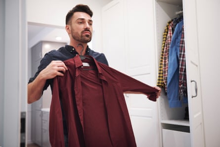 Man choosing shirt from wardrobe