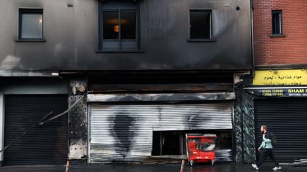 A burnt-out grocery store with burnt-out flats above it