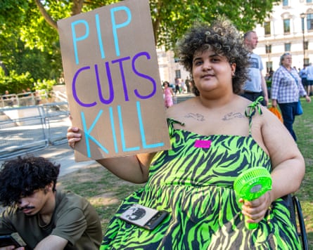A young woman at the Pip protest in Parliament Square last summer holds a cardboard sign saying Pip Cuts Kill.
