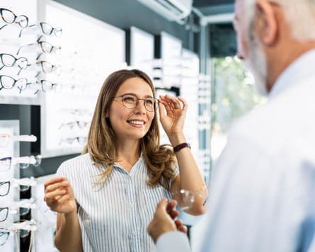 Young female looking astatine different caller glasses to buy
