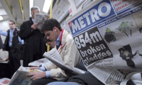 Metro newspaper reader on London tube train