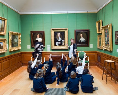 Schoolchildren raising their hands on educational school trip to the Dulwich Picture Gallery, London