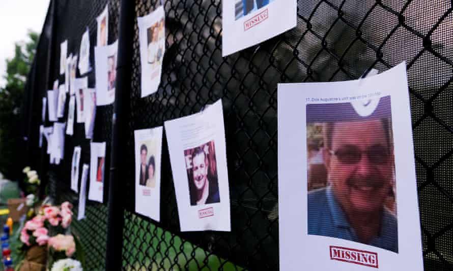 Pictures of missing people at a memorial as rescue personnel continue their search for victims.