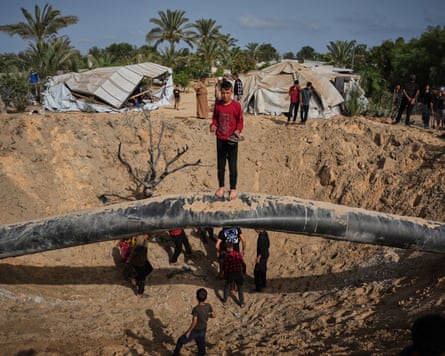 A boy stands surrounded by destruction